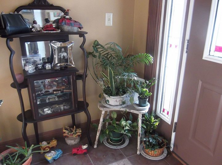 the welcoming plant station, foyer, gardening, A vintage kidney shaped bench is a cozy plant stand her collection of vintage car shape planters add to the charm