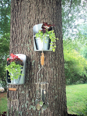 repurposed junk garden, Feed grain scoops again with MWHP s idea of placing them on the tree with our favorite wind chimes we made from flattened spoons and vintage kitchen tools they sound so very pretty