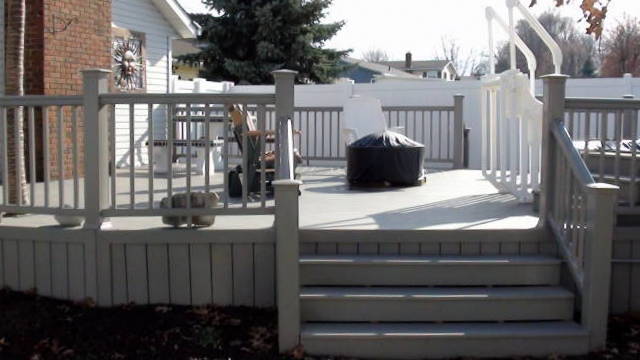 composite decks, decks, A beautiful backyard deck with wide stairs and solid board composite skirting