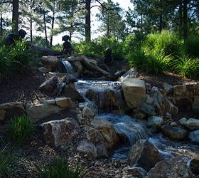 water features through walls, gardening, landscape, outdoor living, ponds water features, wall decor, Beautiful bronze statuary accent a pondless waterfall built in this wooded backyard at Castle Pines CO