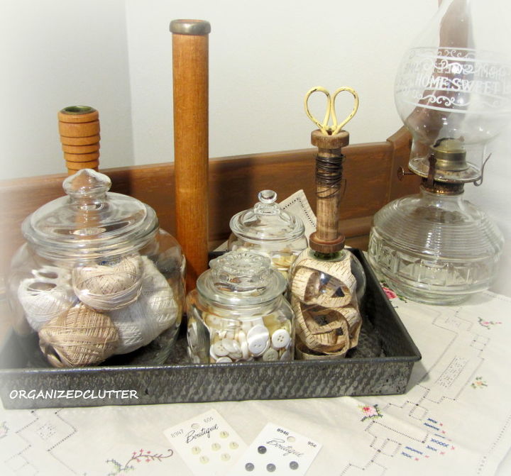 a re purposed glass votive shade two ways, repurposing upcycling, seasonal holiday d cor, valentines day ideas, I put together this vignette with buttons spools thread scissors and a Sears Roebuck vintage measuring tape The tape is displayed under the makeshift cloche