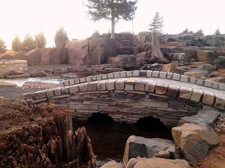 pond bridge, decks, outdoor living, ponds water features, A nice touch to this project that utilized 500 000 pounds of stone to build a pond wetland filter waterfalls fire pit pavilion and stone steps to a remote seating viewing area under the pine beside the cascading water