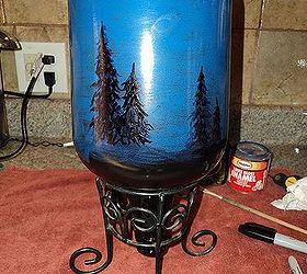starry night light, christmas decorations, crafts, lighting, seasonal holiday decor, 3 Place bottle into the planter holder Using a black Sharpie pen draw in trees all the way around the bottle