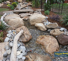 a tranquil meandering stream and koi pond grace this small backyard, landscape, ponds water features, An safe and fun area for the kids to enjoy for hours on end