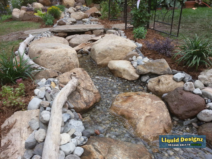 a tranquil meandering stream and koi pond grace this small backyard, landscape, ponds water features, An safe and fun area for the kids to enjoy for hours on end