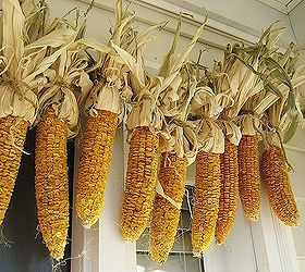 my front porch for fall pumpkins fall flowers lanterns and a fun corn garland, curb appeal, flowers, home decor, seasonal holiday decor, My homemade corn garland hangs over the front door