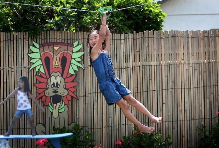 my yard goes disney farrell, outdoor living, pool designs, Molly Farrell tries the new zipline we installed in the family s backyard