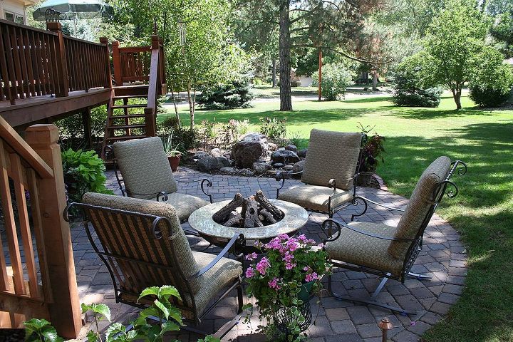 creating a backyard retreat with a new patio water feature and an expanded deck, decks, gardening, landscape, outdoor furniture, patio, ponds water features, The addition of the patio brings a new space to relax at the end of the day By adding a fire table rather than a permanent fire pit the client can enjoy a warm fire with the ability to change the layout to fit their needs