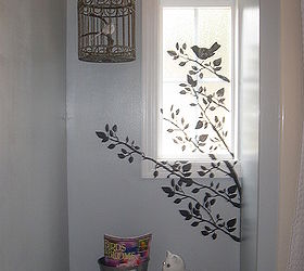 tiny guest bathroom gets character, bathroom ideas, home decor, Painted walls gray stenciled black tree and bird across window and wall Painted trim bright white Bird cage hung with silk ribbon from a Christmas present realistic bird bird s perch is a branch from our woods