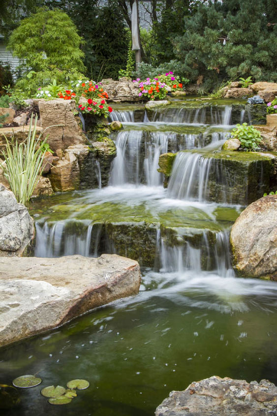 backyard oasis with pond and waterfalls, gardening, outdoor living, ponds water features, A close up view of careful rock placement creating a natural looking waterfall