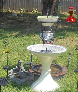solar lights fountains bird baths water for cats dogs too, ponds water features, repurposing upcycling, Now the copper pan is on the grounds which help to keep the water cool I placed a large bowl on the inverted stand The cat frog basin is from my othe home And yes the cats drinl from it The dogs prefer the Copper basin