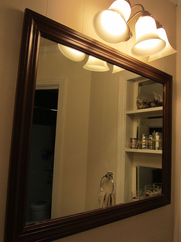 bathroom makeover on a 48 budget, bathroom ideas, home decor, home improvement, shelving ideas, regular mirror added trim and attached with liquid nails Lights have replaced the old round bulbs