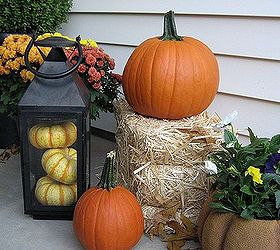 my front porch for fall pumpkins fall flowers lanterns and a fun corn garland, curb appeal, flowers, home decor, seasonal holiday decor, Traditional pumpkins pansies and mums plus a lantern filled with tiger pumpkins line one side of the porch