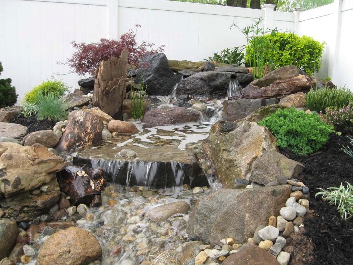 a couple of very cool and unique pondless waterfalls installed by liquid designz in, landscape, outdoor living, ponds water features, One of my favorites This small pondless waterfall has multiple water exits as natural as could be By utilizing the blast holes from these boulders and precise placement we created a piece of art that our client just loved 3 of 3