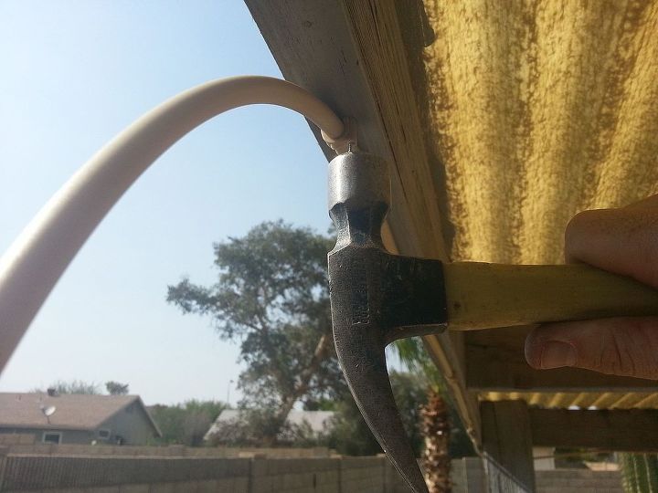 installing a cool misting system to beat the summer heat, outdoor living, I attached it with the included nail in clips They were similar to the little white clips you normally see cable tv wiring only in a delightful tube matching tan