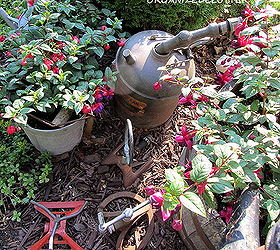 garden junk fuschias, gardening, outdoor living, repurposing upcycling, Here is my sprinkler collection and a gas can and nozzle tucked in among the fuchsias