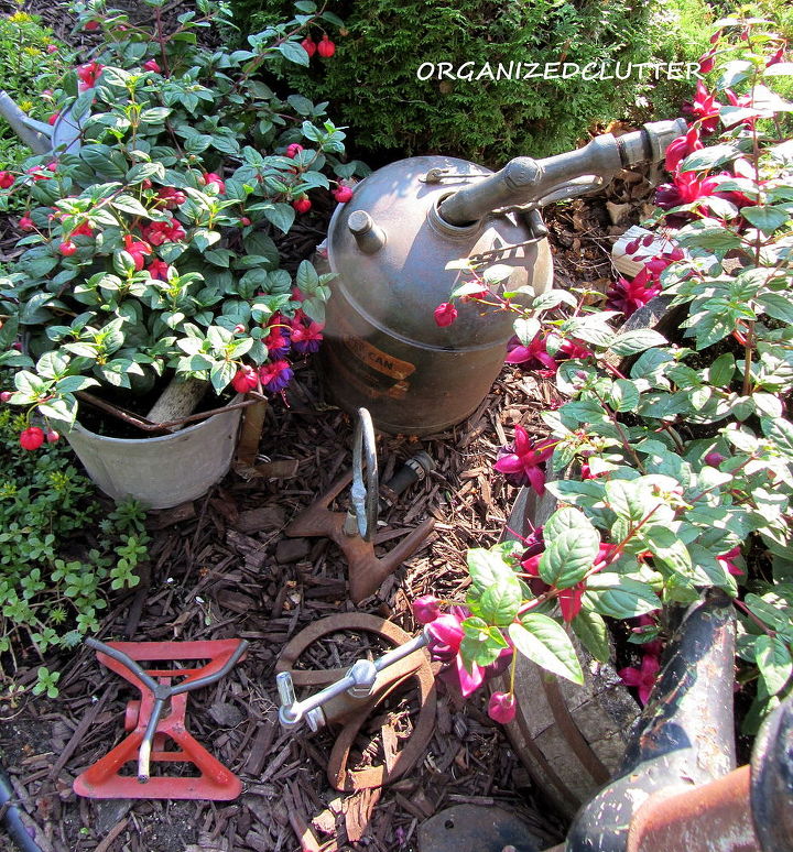 garden junk fuschias, gardening, outdoor living, repurposing upcycling, Here is my sprinkler collection and a gas can and nozzle tucked in among the fuchsias
