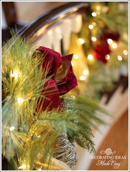 decorating a staircase, foyer, seasonal holiday decor, stairs, Lights were intertwined between the pine branches