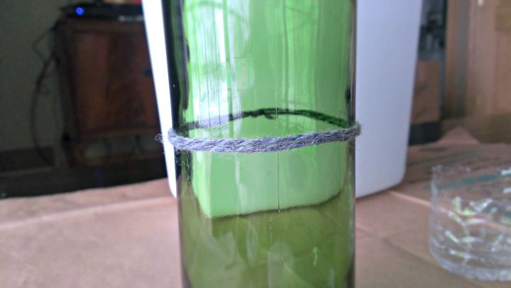cmo cortar una botella de vidrio por la mitad con hilo y fuego, El hilo empapado en acetona se ha rodeado de la botella donde se va a cortar