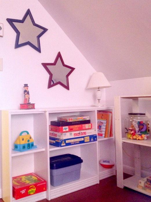 lake house kid s room transformation nautical cottage style, bedroom ideas, home decor, Repurposed book shelf turned toy shelf coats of white paint made it look brand new Star mirrors give a patriotic accent