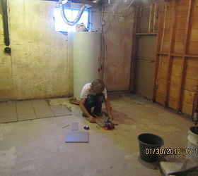 building a new bathroom in basement, basement ideas, bathroom ideas, home improvement, dividing a storage room to storage in the back bathroom in the front My brother putting tiles down