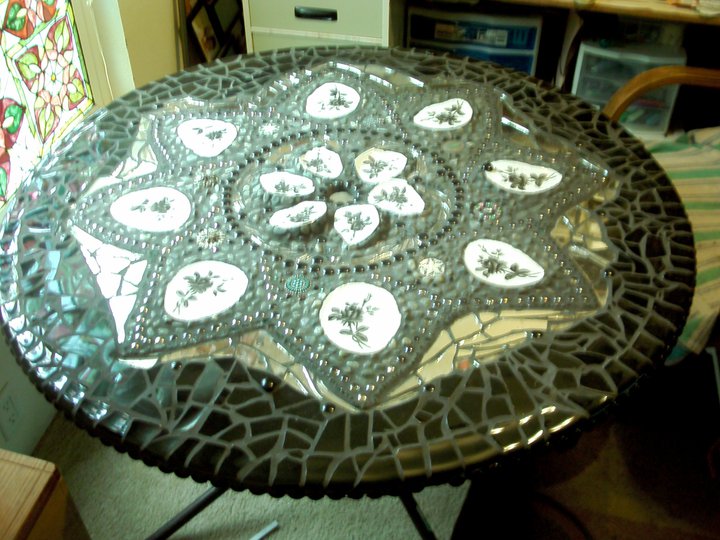 mosaic table, crafts, painted furniture, tiling, I used black plates I bought at wal mart a buck a piece my slurge on expenses so that this would all come together color wise grouting it was a lot of work but this is now a great addition to my yard