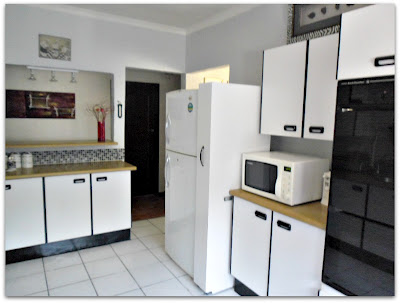 kitchen make over the budget friendly way, countertops, home decor, kitchen design, tiling, Breakfast bar to the left chairs are actually in the passage so you eat breakfast facing the kitchen see how nicely the sliding grocery unit tucks away next to the refrigerator