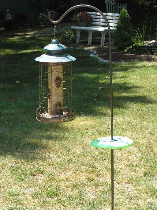 squirrel proof bird feeder what about those chipmunks, outdoor living, pets animals, To keep chipmunks from climbing up your shepherd s hook to get to the goodies just drill a hole in the center of a Frisbee 97 cents at Walmart Wrap some duct tape where you want it to sit so it doesn t slide down to the ground