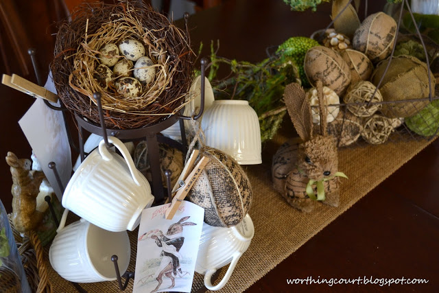 my burlapy and vintagey easter centerpiece, easter decorations, seasonal holiday d cor, In addition to the nest and printed images there are burlap covered eggs hanging from the mug tree