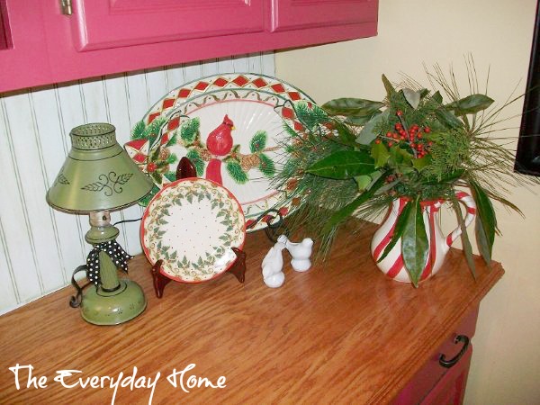 a southern kitchen with red painted cabinets perfect setting for christmas, christmas decorations, seasonal holiday decor, A large cardinal platter and a pitcher of fresh greens