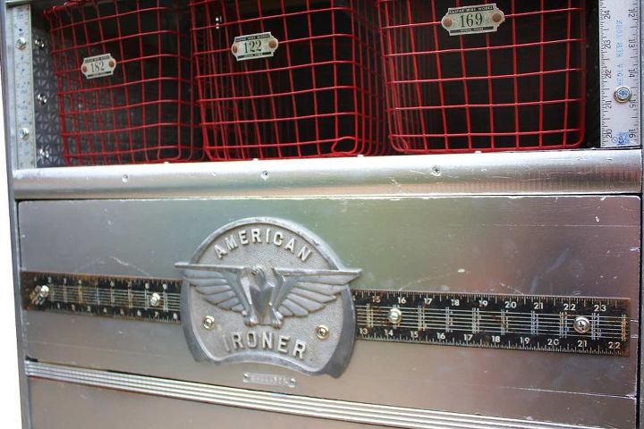 cmoda industrial cromada e vermelha, Um antigo emblema de metal e partes de um velho quadrado de carpinteiro de metal vestem o painel frontal fixo