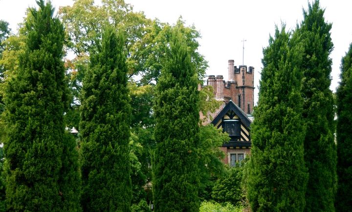 stan hywet s great garden part 2 the cutting garden, flowers, gardening, landscape, An unusual sight in Ohio Stan Hywet Hall stands in its Tudor splendor as framed by the pillar shrubs of the Elliptical Garden This garden can be seen walking from the Great Garden to the Carriage House which is the official visitor