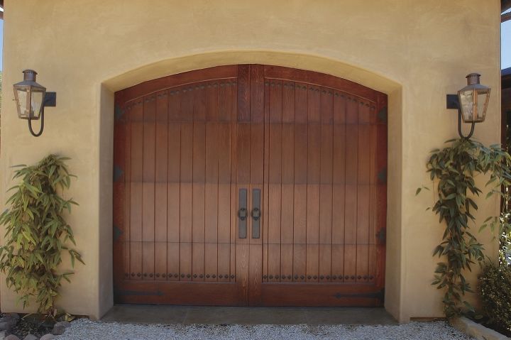 wood carriage house garage doors, Clopay Reserve Collection Custom insulated garage door Factory Stained Mahogany Decorative hardware Door Studs Ring Door Knockers w Plate and Spade Strap Hinges Featured in Traditional Home magazine