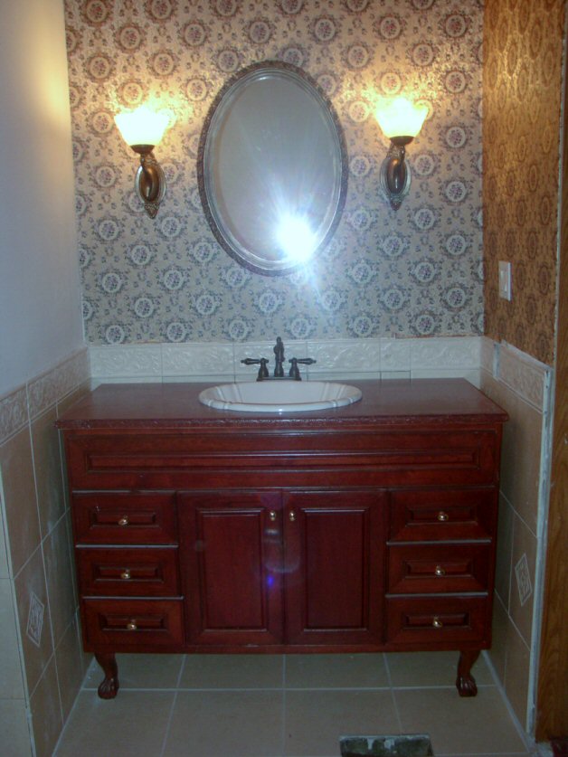 q how to remove dried sanded grout, cleaning tips, tiling, This is the sink area the claw foot vanity we made out of a damaged cherry cabinet my husbands work was going to pitch after the forklift damaged it We fixed it and custom ordered the cherry wood top and treated with spar poly urethane and trimmed it out with molding and attached feet and I stained it all to match The bowl and faucet were clearance items 20 and 25 respectively The mirror I picked out of someones trash and ordered the swan sconces in chrome on ebay for 5 each painted and used rub n buff to antique them The alabaster shades I will someday change out when I find ones I like better that are taller I got those for 3 each You can see some of the grout on the tiles here too I did get the swirls scrubbed off