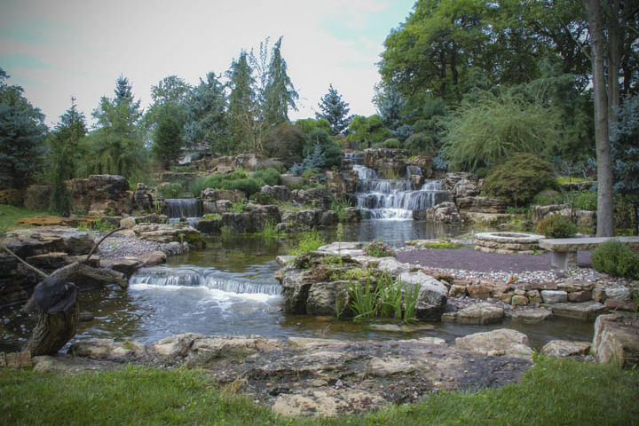 expansive waterfalls and pond in crown point indiana, outdoor living, patio, ponds water features, To the right is a patio with firepit