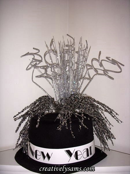 new year s tablescape, seasonal holiday decor, New Year s Vignette a black top hat and in a crystal vase just behind the hat I added black silver beaded sprays silver holographic glittered sprays silver glittered curly Ting Ting