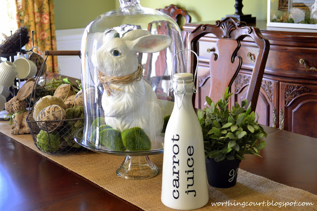 my burlapy and vintagey easter centerpiece, easter decorations, seasonal holiday d cor, A bunny with a raffia bow tie is keeping his eye on this bottle of carrot juice