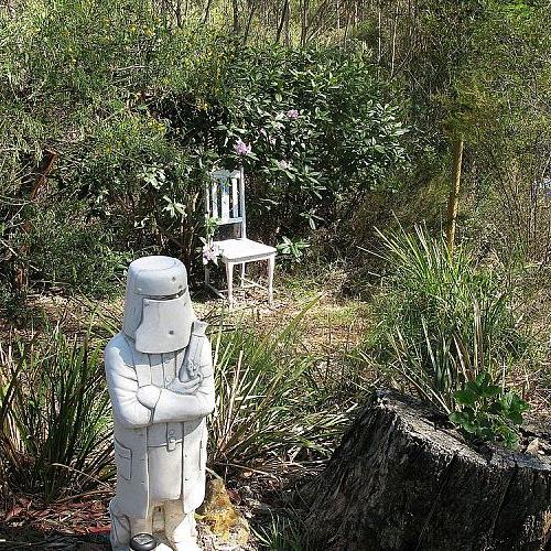 garden art and features, flowers, gardening, outdoor living, succulents, A statue of Ned Kelly next to a tree stump planted up with a strawberry plant