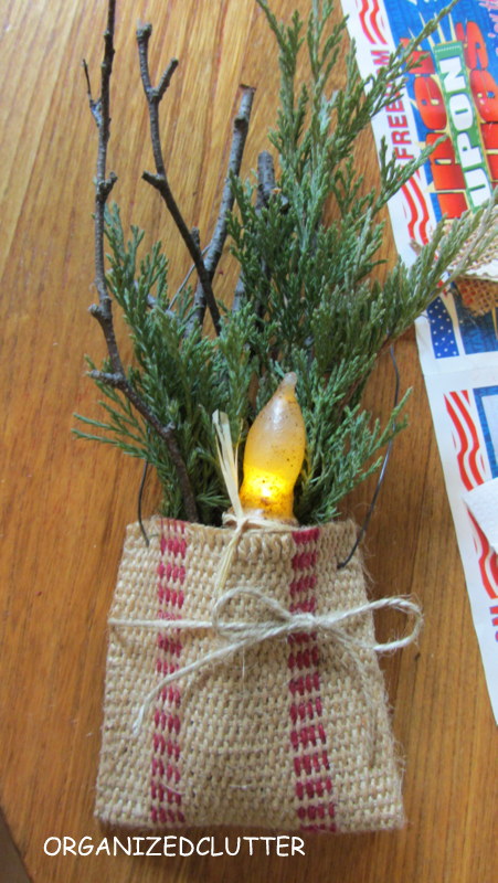 crafting with jute webbing, crafts, seasonal holiday decor, I stuffed the little pouch with birch twigs and juniper greenery from my yard and stuffed the little candle in the front I then tied a piece of jute in a bow around the pouch
