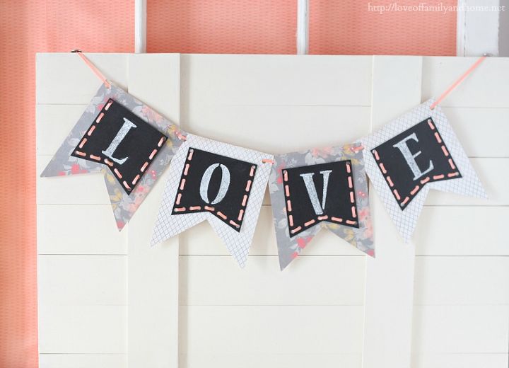 valentine s day chalkboard pennant banner, chalkboard paint, crafts, seasonal holiday decor, valentines day ideas, I glued the chalkboard pennants to the scrapbook pennants the punch holes in the corners with a hole punch Then I used ribbon to string my banner together hang