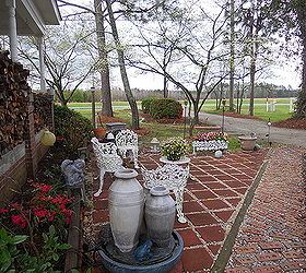 flower gardening turning a dead area into a southern style courtyard, decks, flowers, outdoor furniture, outdoor living, The courtyard is divided into two halves by a brick walkway Neighbors and friends gave us a lot of cuttings and flower bulbs One friend was moving and had no place to put her cast iron lawn furniture When she visited she said she had something for me and made me a gift of the furniture which is almost 100 years old Inexpensive mini pansies and trailing pansies offer color and southern charm to this furniture We are enjoying what was once a horrible eyesore
