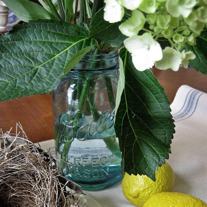 mason jars and bird nests a simple summer centerpiece, home decor, seasonal holiday decor, My vintage blue mason jar serves as a vase for a bouquet of summery flowers