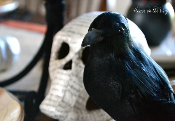 spooky halloween party decor, crafts, halloween decorations, seasonal holiday decor, A black crow from the Dollar Tree and a decoupaged book page skull add to the spookiness
