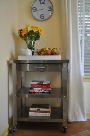 a fresh start for a breakfast nook, home decor, kitchen design, The wheeled Danver stainless steel professional kitchen cart featuring two shelves a front drawer and a side towel bar and hooks for utensils replaced an old style butcher block cart