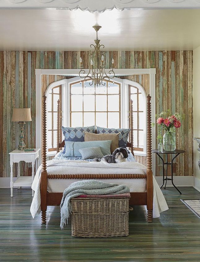 house tour a lively cottage revival, architecture, home decor, Blue and aqua bedding plays off the hues in the weathered wood walls and floor A pair of mismatched nightstands brings the room s formal four poster bed down to earth