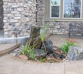 a spouting rock certainly adds interest to any landscape without the work of a pond, outdoor living, ponds water features, A pouting rock at this homeowner s front door adds interest and the sound of water