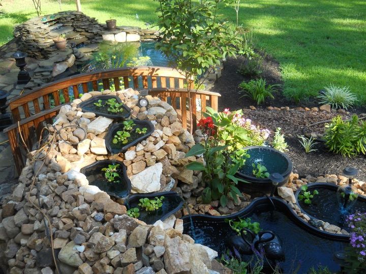 first pond ever, outdoor living, patio, ponds water features, Same pond just bigger Stucture was 4 1 2 feet tall and wrapped around the end with the 4 cascading tiers Here is a pic of the finish in August 2011 The natural rock came from our ground from making flower beds and grading out our own driveway that was paved We are on a rock vein here Every shovel was a rock Digging bar was our best friend Unfortunately the earthquake collapsed it in August Glad I had pics to remember it It took a year and half to get all this rock from the ground and continuously add to it I still have all of it and thinking I may just do another one in the back yard