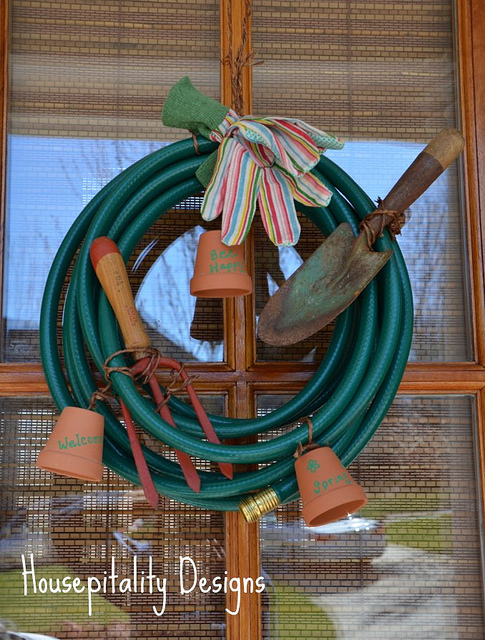 a garden hose wreath, home decor, wreaths, A garden hose small terracotta pots and gloves for a bow