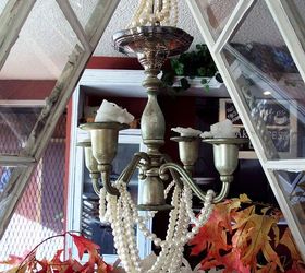 mini greenhouse from old windows that changes with the seasons, I added some bling by turning a silver candelabra upside down hanging it from the roof and adding some faux pearl jewelry to make a chandelier