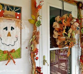 a country cottage s fall porch tour, decks, porches, seasonal holiday decor, wreaths, A scarecrow wreath and garland surround the front door Beside the garland are two hand painted burlap scarecrows